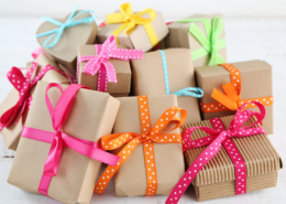 Pile of gifts with colorful ribbons against a white background.